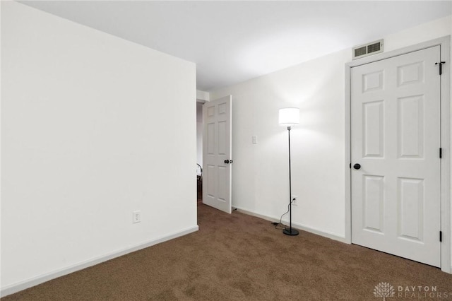 unfurnished bedroom featuring carpet, visible vents, and baseboards