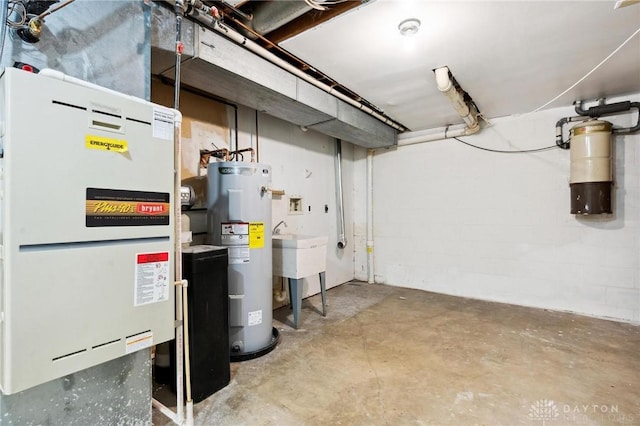 unfinished below grade area featuring a sink, concrete block wall, electric water heater, and heating unit