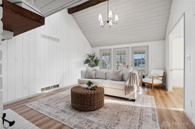 living room with high vaulted ceiling, light hardwood / wood-style floors, and a chandelier