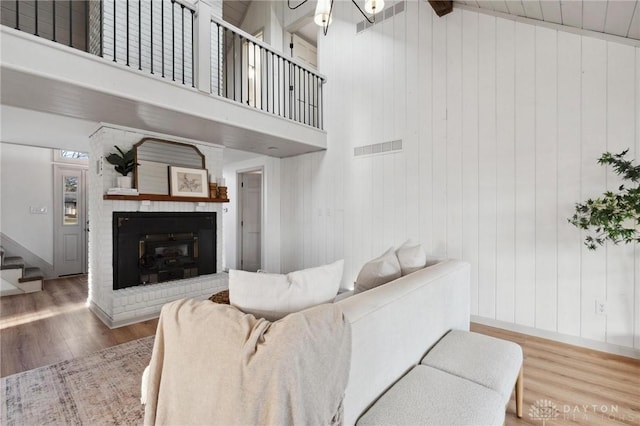 living room with a towering ceiling, hardwood / wood-style floors, and a fireplace