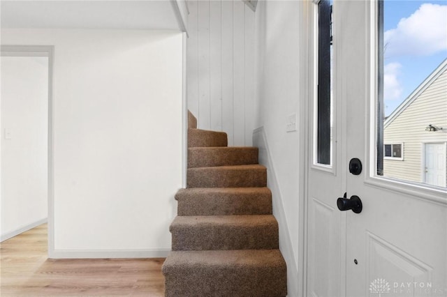 staircase with wood finished floors and baseboards