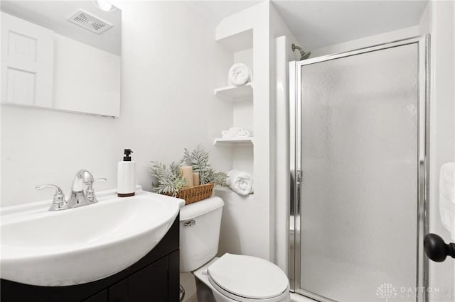 full bath featuring toilet, a stall shower, vanity, and visible vents