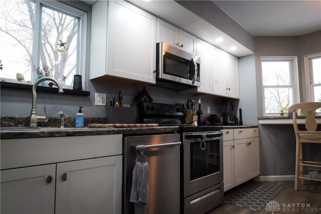 kitchen featuring white cabinetry, sink, dark hardwood / wood-style flooring, and appliances with stainless steel finishes