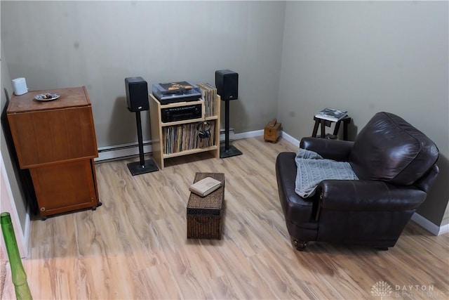 sitting room featuring a baseboard heating unit and light hardwood / wood-style flooring