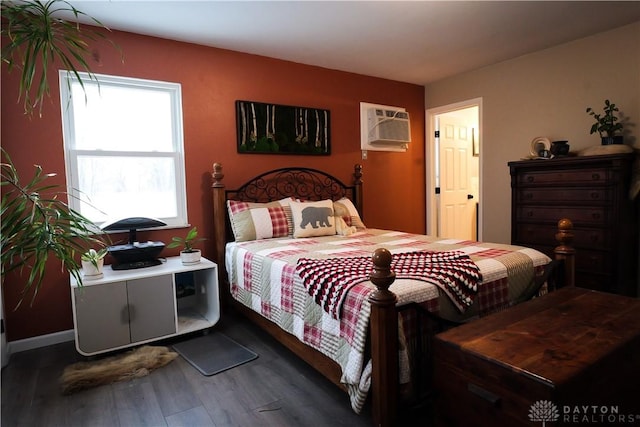 bedroom featuring dark hardwood / wood-style flooring and an AC wall unit