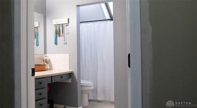 bathroom featuring tasteful backsplash, toilet, and a shower with curtain