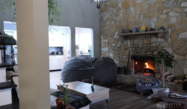 living room with a towering ceiling, a fireplace, and hardwood / wood-style floors