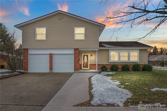 view of front of property with a garage and a lawn