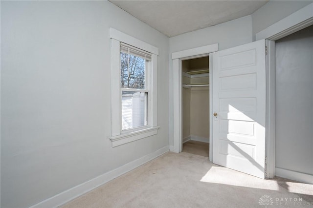 unfurnished bedroom featuring a closet and light carpet