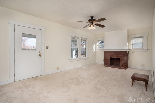 unfurnished living room with a brick fireplace, baseboards, a ceiling fan, and carpet flooring