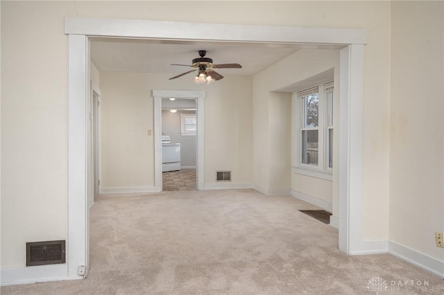 carpeted empty room featuring ceiling fan and washer / clothes dryer