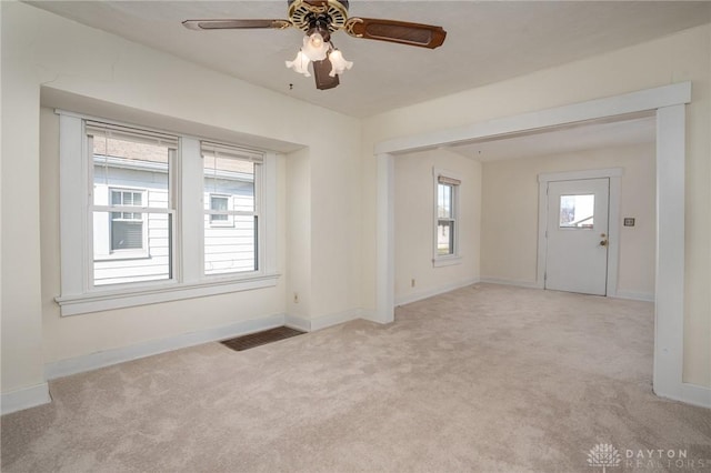 carpeted spare room with ceiling fan