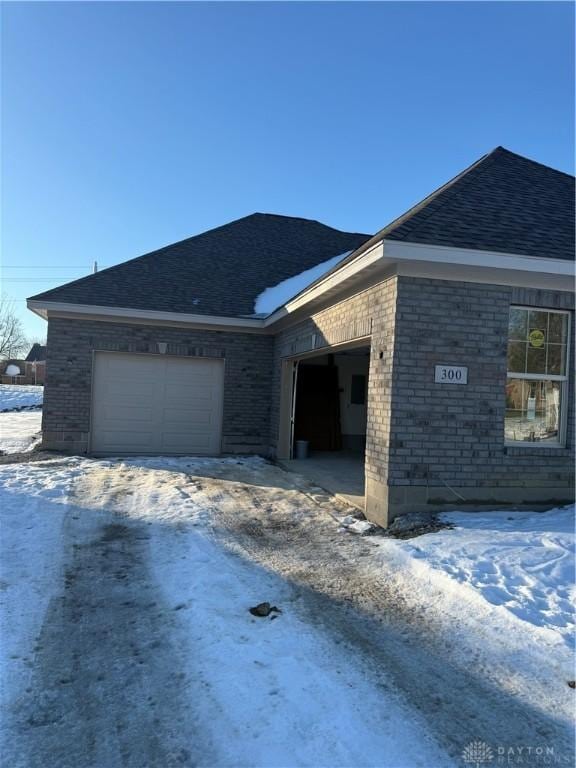 snow covered property with a garage