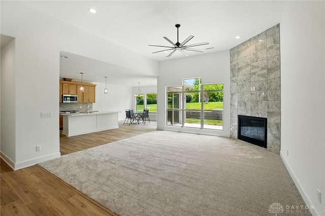 300 Grassy Creek Way, Washington Twp, OH 45458 - unfurnished living room featuring ceiling fan, baseboards, recessed lighting, light wood finished floors, and a tiled fireplace