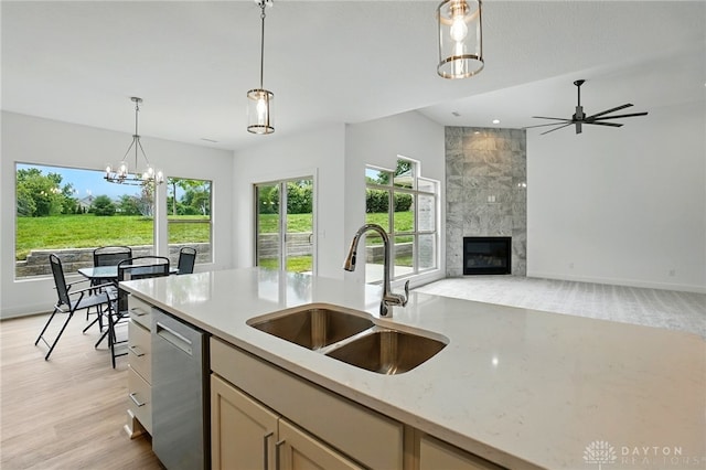 300 Grassy Creek Way, Washington Twp, OH 45458 - kitchen with a sink, stainless steel dishwasher, decorative light fixtures, a high end fireplace, and light stone countertops