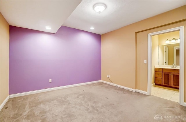 unfurnished room featuring sink and light carpet