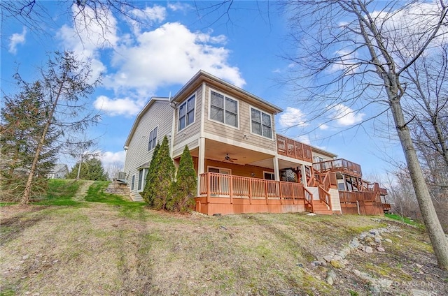 view of front facade featuring ceiling fan, a deck, and a front lawn