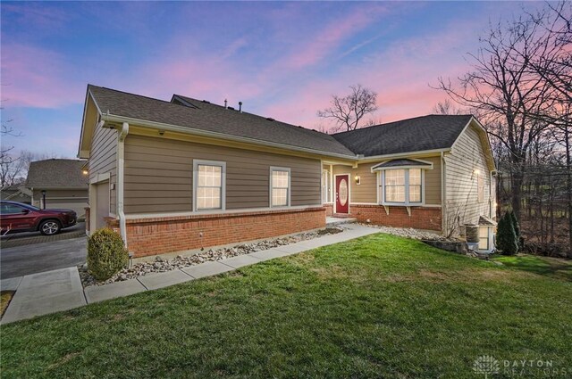 ranch-style home with a yard and a garage