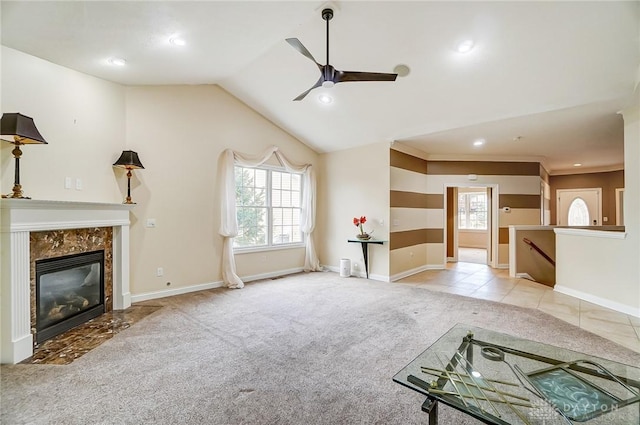 unfurnished living room featuring lofted ceiling, a high end fireplace, plenty of natural light, and light colored carpet