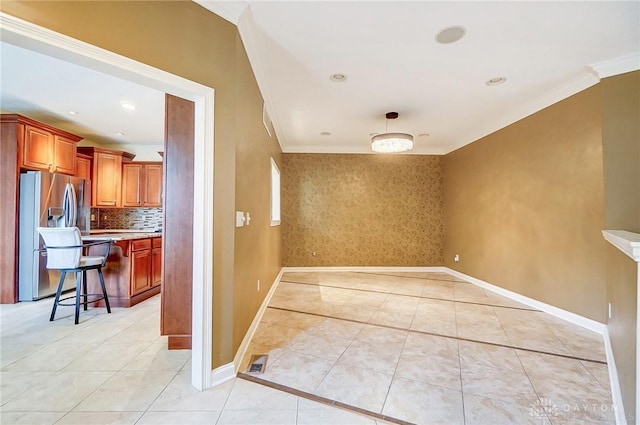 tiled empty room featuring crown molding