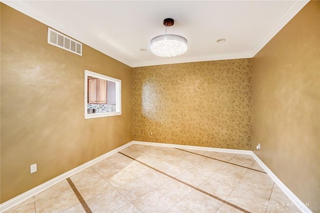 tiled spare room featuring ornamental molding and a chandelier