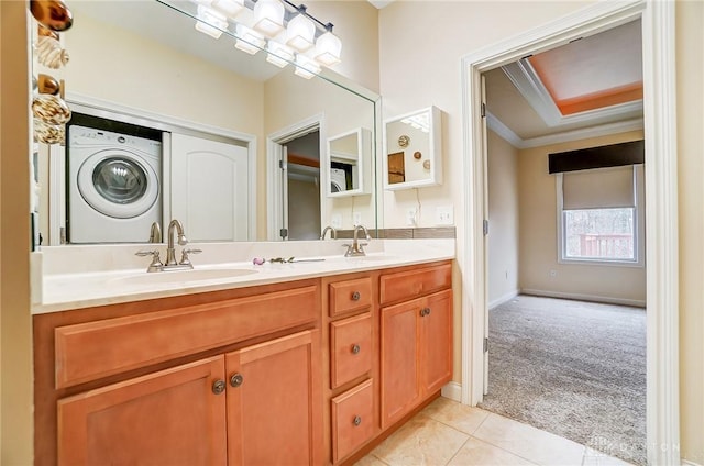 bathroom featuring tile patterned floors, ornamental molding, washer / clothes dryer, and vanity