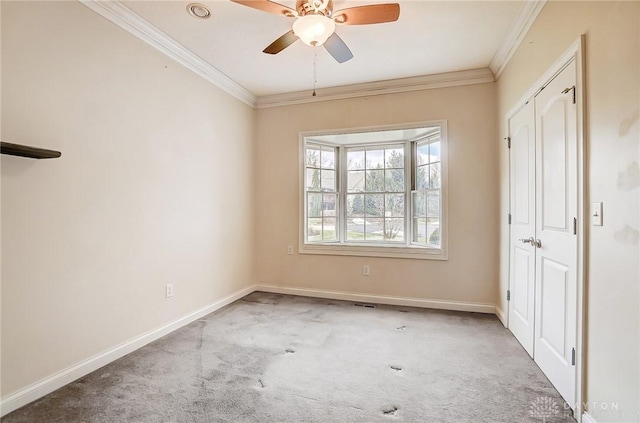 empty room with crown molding, carpet flooring, and ceiling fan