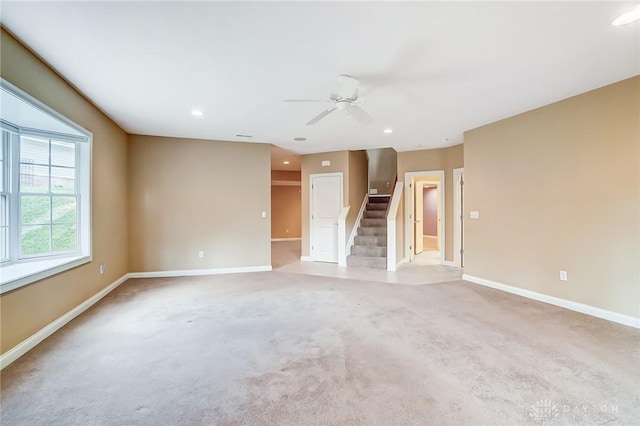 carpeted spare room featuring ceiling fan