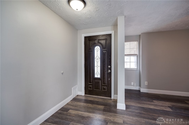 foyer with a textured ceiling and dark hardwood / wood-style flooring