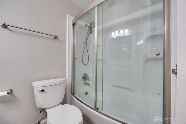 bathroom with shower / bath combination with glass door and toilet