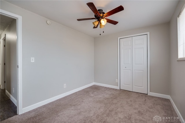 unfurnished bedroom featuring ceiling fan, a closet, and carpet