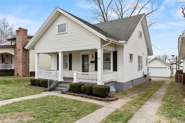 bungalow-style house featuring a garage, an outdoor structure, covered porch, and a front lawn