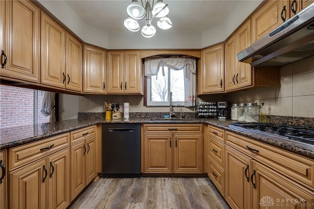 kitchen with sink, dark stone counters, dishwasher, stainless steel gas stovetop, and hardwood / wood-style floors