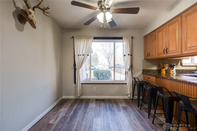 dining room with dark hardwood / wood-style flooring and ceiling fan