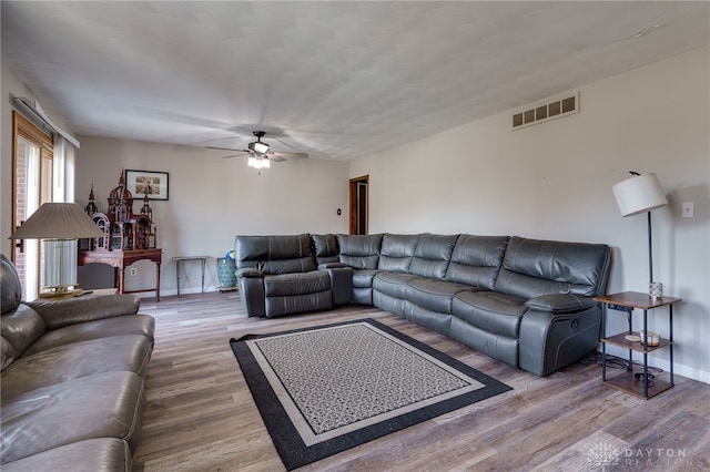 living room featuring hardwood / wood-style floors and ceiling fan