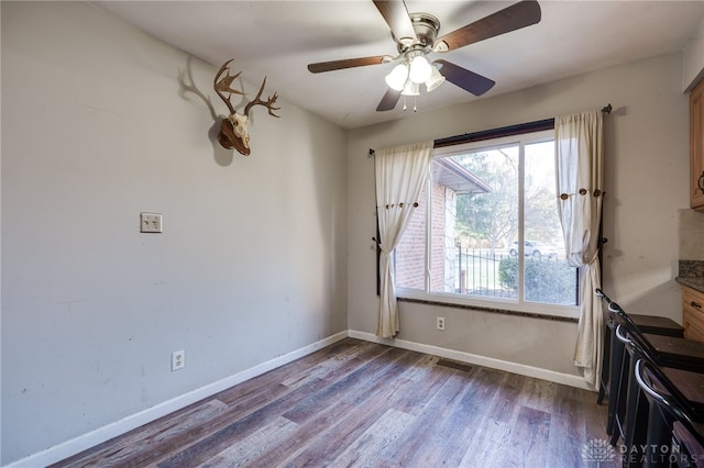 unfurnished room with ceiling fan and dark hardwood / wood-style floors