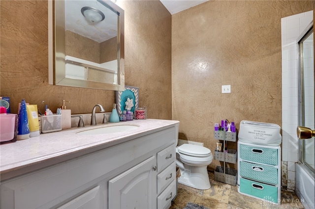 full bathroom featuring vanity, bath / shower combo with glass door, and toilet