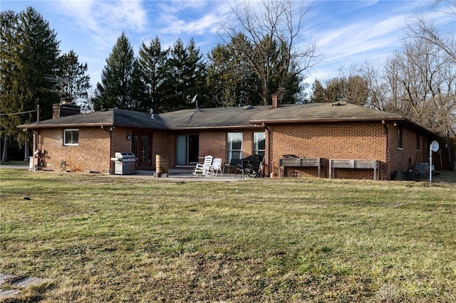 back of house featuring a patio area and a lawn