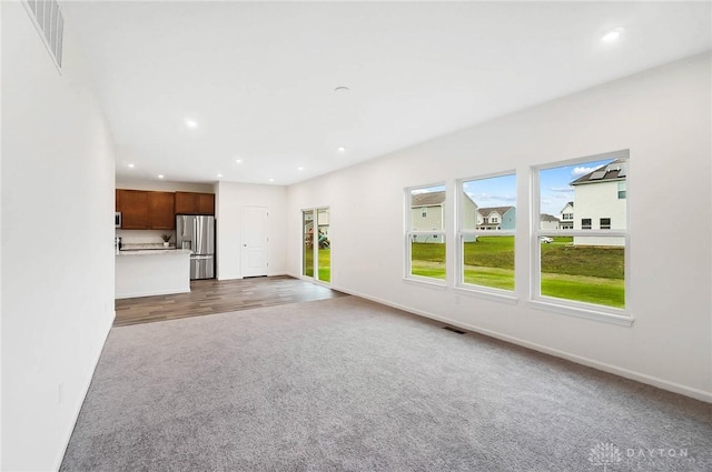 unfurnished living room featuring dark carpet