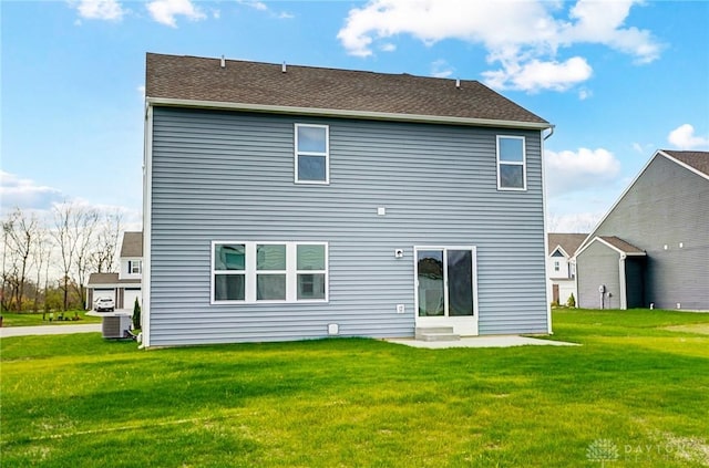 rear view of house featuring a yard and central AC