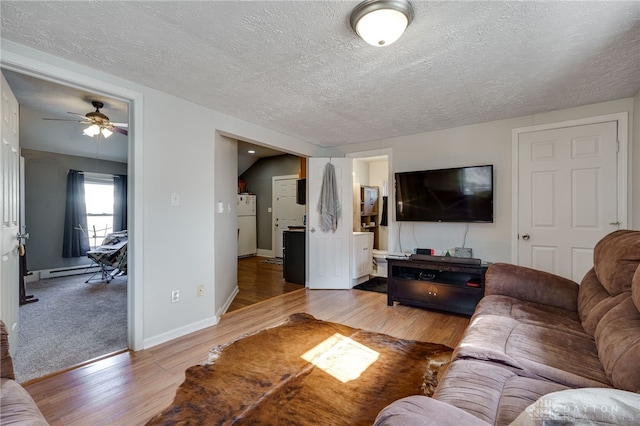 living room featuring a textured ceiling, light hardwood / wood-style floors, and baseboard heating