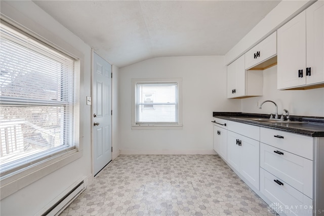 kitchen featuring sink, a baseboard radiator, white cabinets, and vaulted ceiling