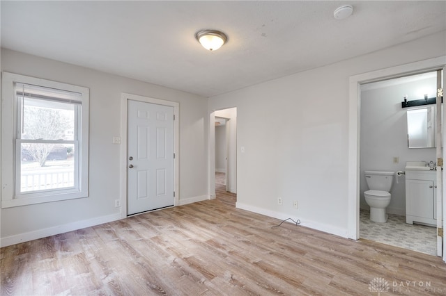 interior space with ensuite bath and light hardwood / wood-style flooring