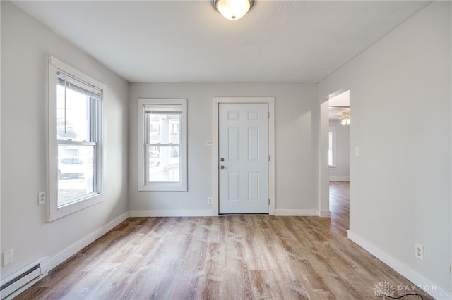 foyer with light hardwood / wood-style floors and a baseboard heating unit