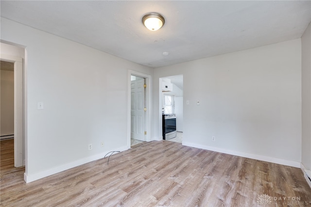 unfurnished room featuring light hardwood / wood-style flooring and baseboard heating