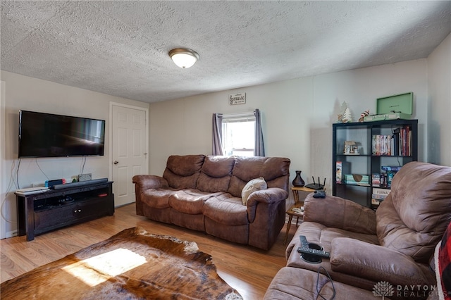 living room featuring a textured ceiling and light wood-type flooring