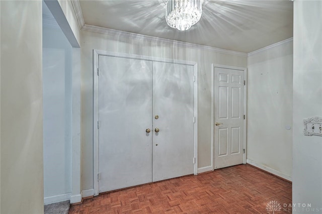 entrance foyer featuring crown molding, parquet flooring, and a notable chandelier