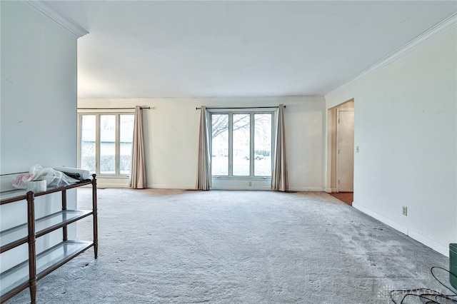 empty room featuring light carpet, crown molding, and a healthy amount of sunlight