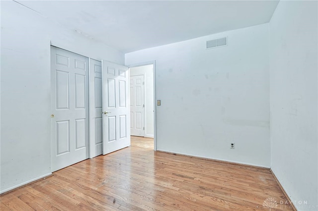 unfurnished bedroom with light hardwood / wood-style floors and a closet