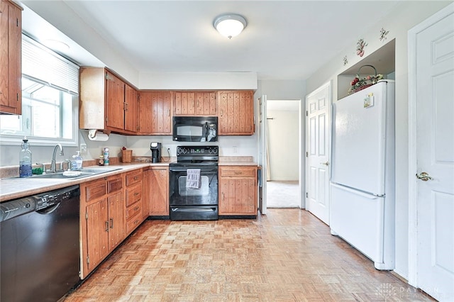 kitchen with sink, black appliances, and light parquet floors